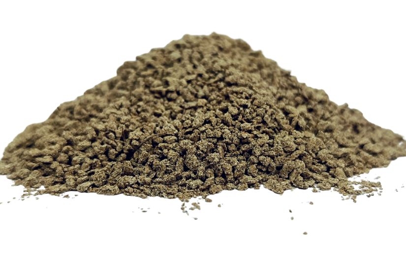 Chamomile granules (Matricaria chamomilla) pile on white background